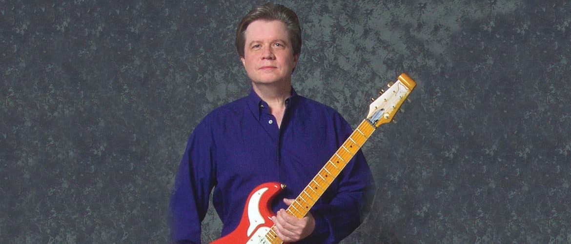 Art Greenhaw holding a red electric guitar