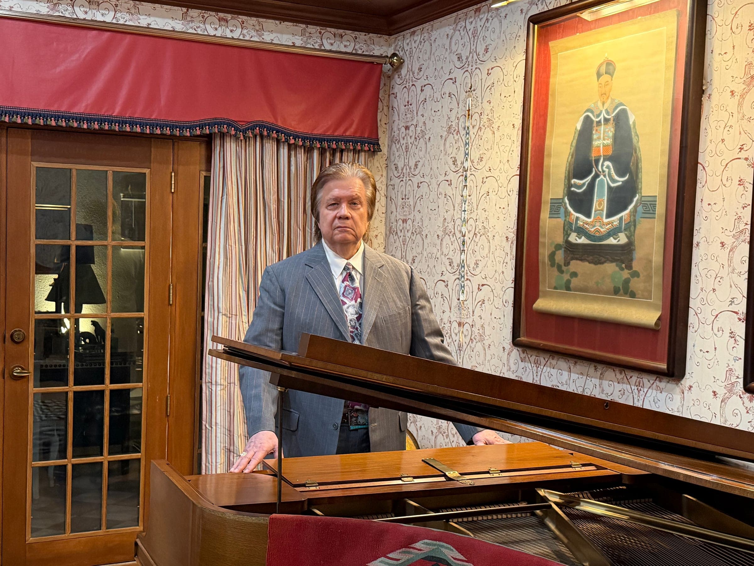 Art Greenhaw standing behind a grand piano with its lid raised